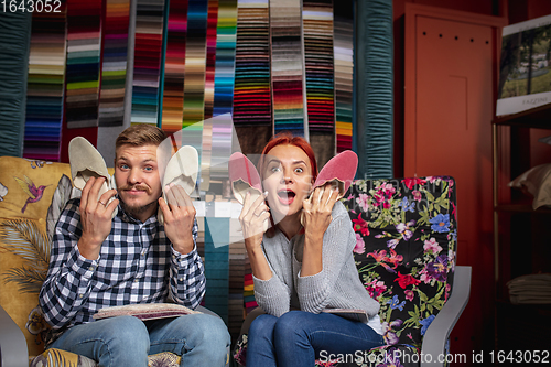 Image of Couple choosing textile at home decoration store, shop. Making of home interior design during quarantine