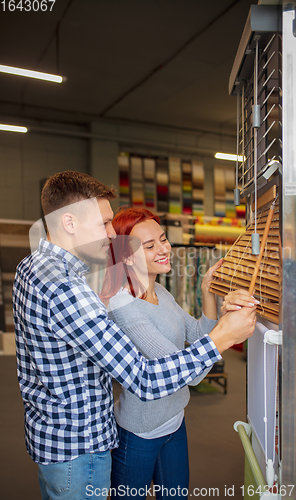 Image of Couple choosing textile at home decoration store, shop. Making of home interior design during quarantine