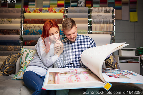 Image of Couple choosing textile at home decoration store, shop. Making of home interior design during quarantine