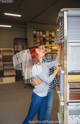 Image of Couple choosing textile at home decoration store, shop. Making of home interior design during quarantine