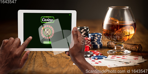 Image of Online gambling, casino concept. Hand holding device with lottery, casino cover