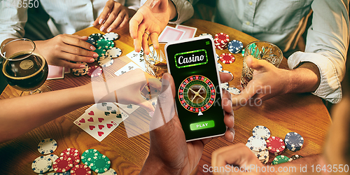 Image of Online gambling, casino concept. Hand holding device with lottery, casino cover