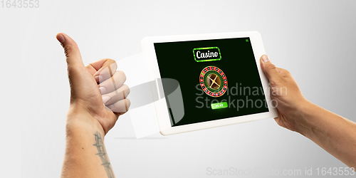 Image of Online gambling, casino concept. Hand holding device with lottery, casino cover