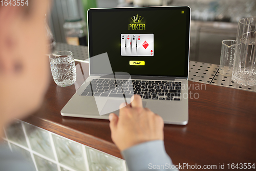 Image of Online gambling, casino concept. Hand near laptop, device with lottery, casino cover