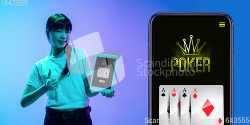 Image of Online gambling, casino concept. Young asian woman holding devices with lottery, casino cover in neon light