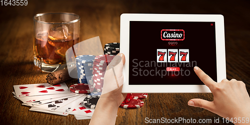 Image of Online gambling, casino concept. Hand holding device with lottery, casino cover