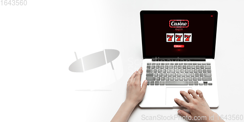 Image of Online gambling, casino concept. Hand near laptop, device with lottery, casino cover