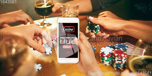 Image of Online gambling, casino concept. Hand holding device with lottery, casino cover