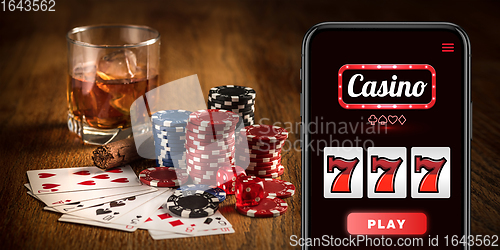 Image of Online gambling, casino concept. Hand holding device with lottery, casino cover