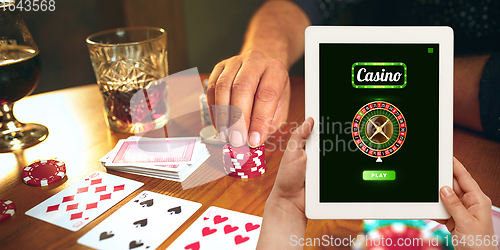 Image of Online gambling, casino concept. Hand holding device with lottery, casino cover