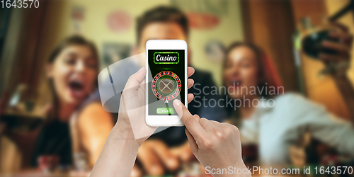 Image of Online gambling, casino concept. Hand holding device with lottery, casino cover