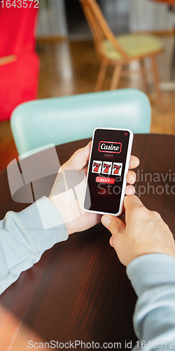 Image of Online gambling, casino concept. Hand holding device with lottery, casino cover