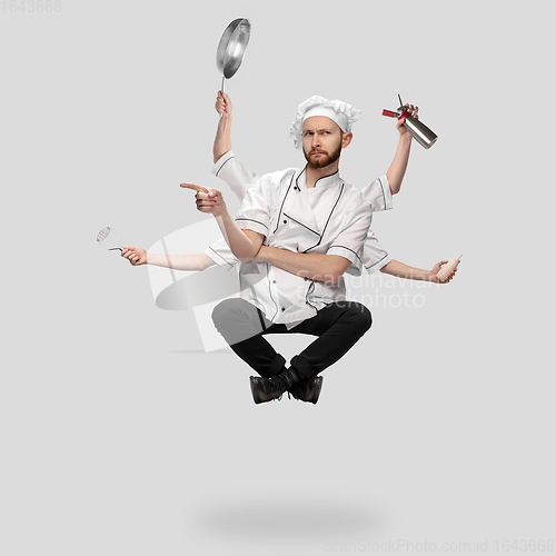 Image of Cooker, chef, baker in uniform multitask like shiva isolated on gray studio background