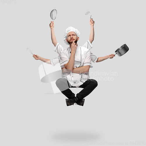 Image of Cooker, chef, baker in uniform multitask like shiva isolated on gray studio background