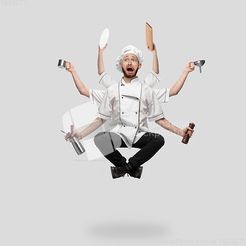 Image of Cooker, chef, baker in uniform multitask like shiva isolated on gray studio background