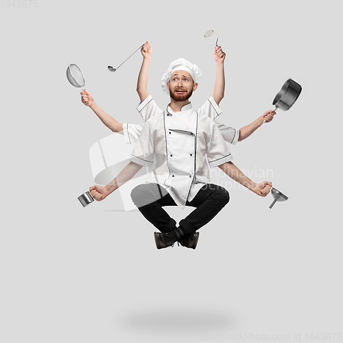 Image of Cooker, chef, baker in uniform multitask like shiva isolated on gray studio background