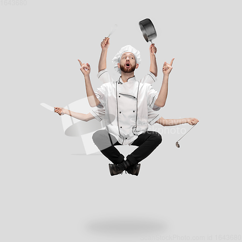 Image of Cooker, chef, baker in uniform multitask like shiva isolated on gray studio background