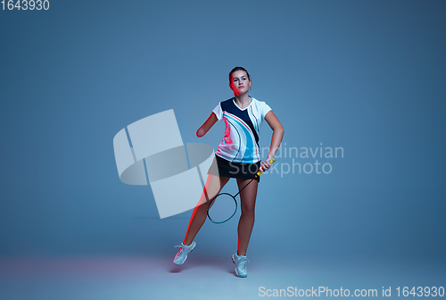 Image of Beautiful handicap woman practicing in badminton isolated on blue background in neon light