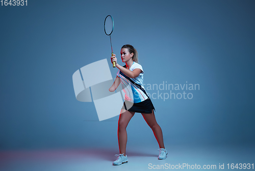 Image of Beautiful handicap woman practicing in badminton isolated on blue background in neon light