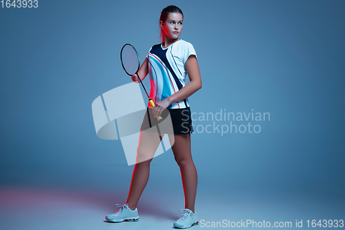 Image of Beautiful handicap woman practicing in badminton isolated on blue background in neon light