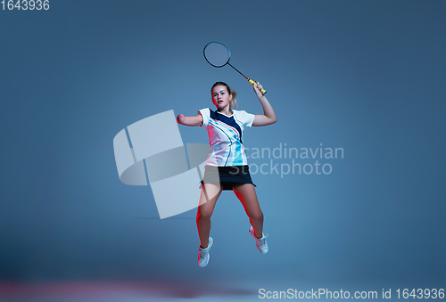 Image of Beautiful handicap woman practicing in badminton isolated on blue background in neon light