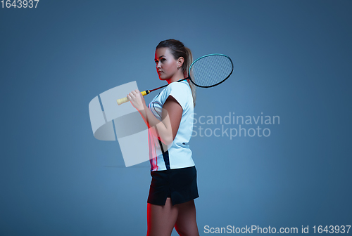 Image of Beautiful handicap woman practicing in badminton isolated on blue background in neon light