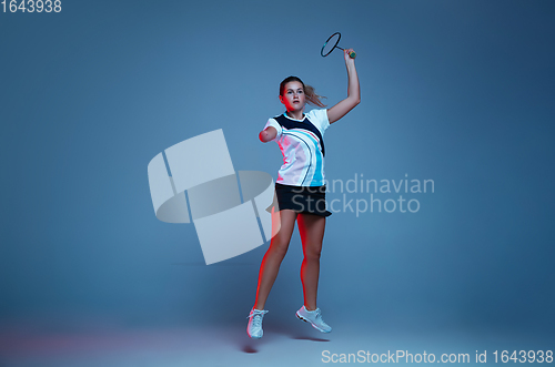 Image of Beautiful handicap woman practicing in badminton isolated on blue background in neon light