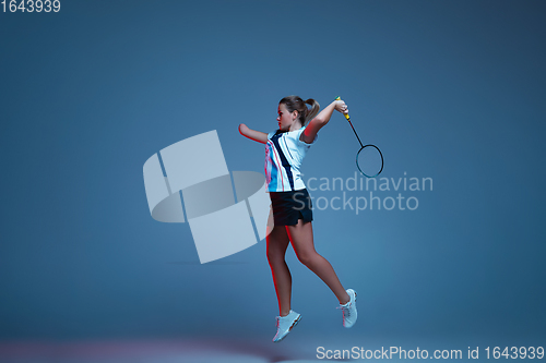 Image of Beautiful handicap woman practicing in badminton isolated on blue background in neon light