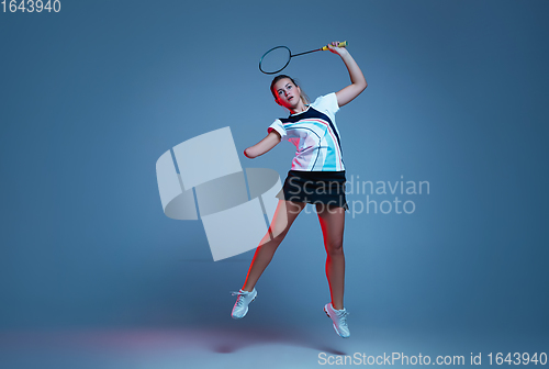 Image of Beautiful handicap woman practicing in badminton isolated on blue background in neon light