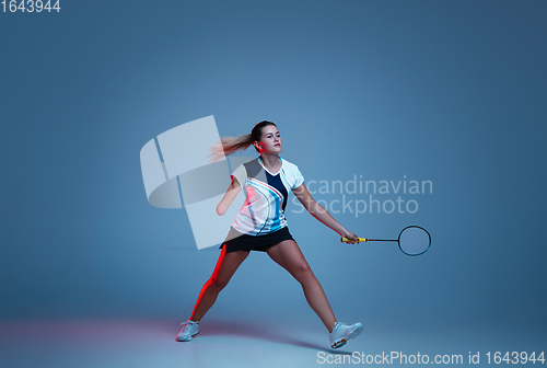 Image of Beautiful handicap woman practicing in badminton isolated on blue background in neon light