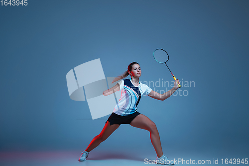 Image of Beautiful handicap woman practicing in badminton isolated on blue background in neon light