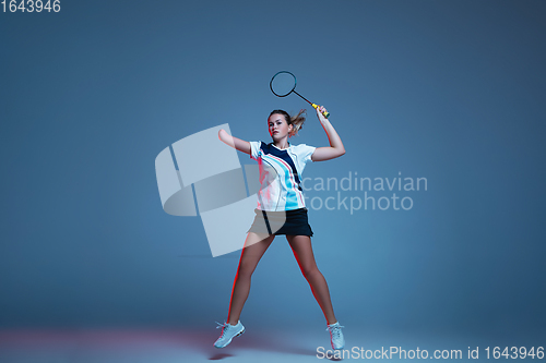 Image of Beautiful handicap woman practicing in badminton isolated on blue background in neon light