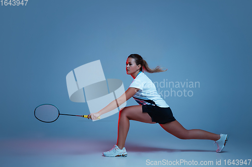 Image of Beautiful handicap woman practicing in badminton isolated on blue background in neon light