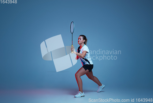 Image of Beautiful handicap woman practicing in badminton isolated on blue background in neon light