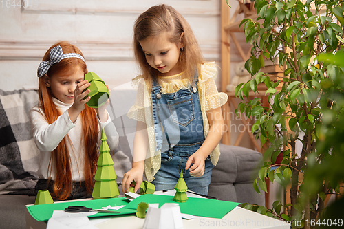 Image of Two little children, girls together in creativity of the house. Happy kids make handmade toys for games or New Year celebration