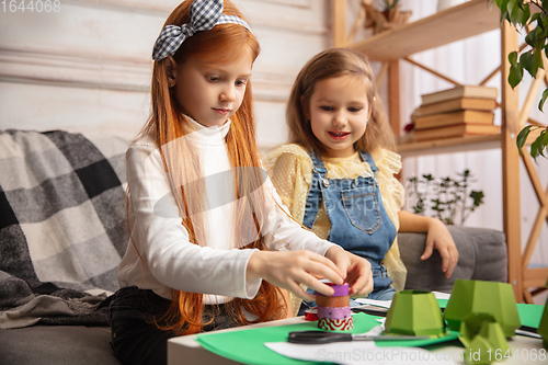 Image of Two little children, girls together in creativity of the house. Happy kids make handmade toys for games or New Year celebration