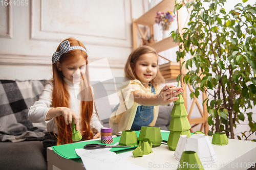 Image of Two little children, girls together in creativity of the house. Happy kids make handmade toys for games or New Year celebration
