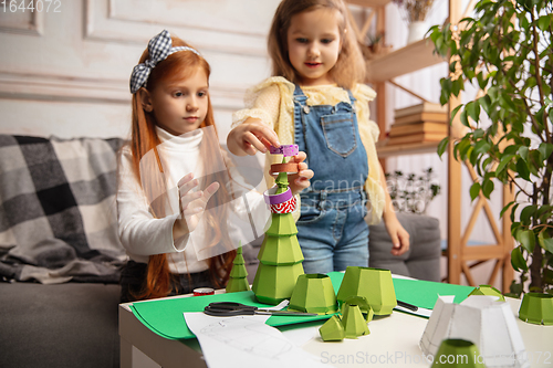 Image of Two little children, girls together in creativity of the house. Happy kids make handmade toys for games or New Year celebration