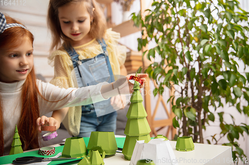 Image of Two little children, girls together in creativity of the house. Happy kids make handmade toys for games or New Year celebration