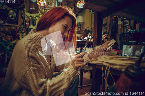 Image of Smiling woman looking for home decoration and holiday\'s gifts in household store