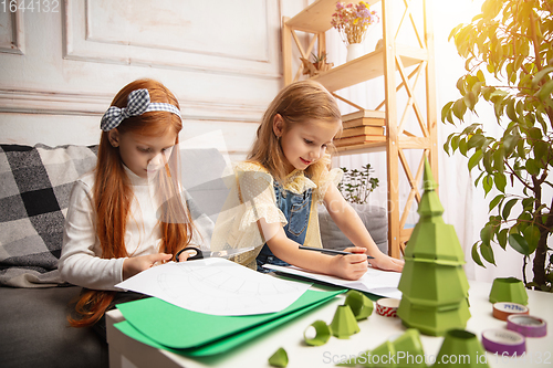 Image of Two little children, girls together in creativity of the house. Happy kids make handmade toys for games or New Year celebration