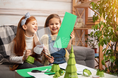 Image of Two little children, girls together in creativity of the house. Happy kids make handmade toys for games or New Year celebration