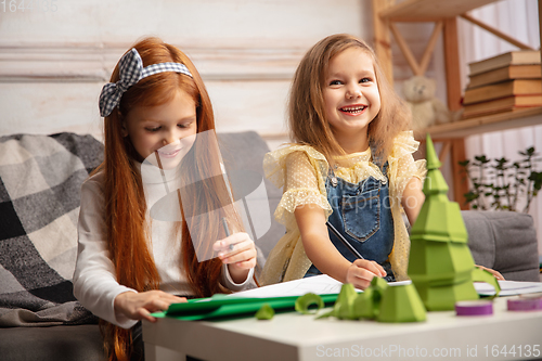 Image of Two little children, girls together in creativity of the house. Happy kids make handmade toys for games or New Year celebration