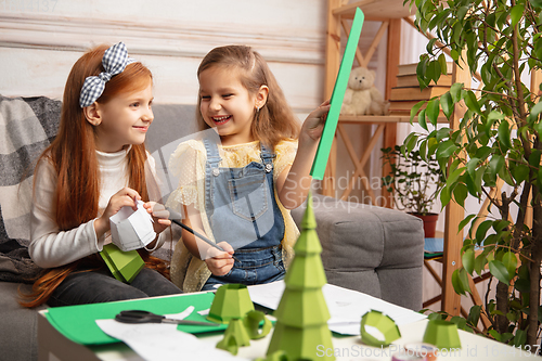 Image of Two little children, girls together in creativity of the house. Happy kids make handmade toys for games or New Year celebration