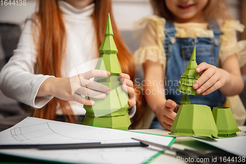 Image of Close up hands of two little children, girls together in creativity of the house. Kids make handmade toys for games or New Year celebration