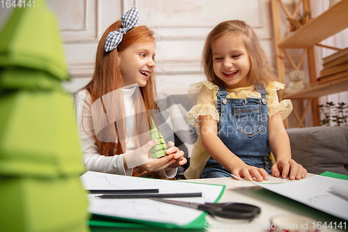 Image of Two little children, girls together in creativity of the house. Happy kids make handmade toys for games or New Year celebration