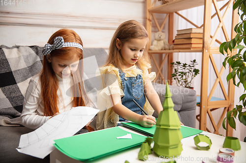 Image of Two little children, girls together in creativity of the house. Happy kids make handmade toys for games or New Year celebration