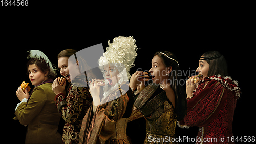 Image of Medieval people as a royalty persons in vintage clothing on dark background. Concept of comparison of eras, modernity and renaissance. Creative collage.