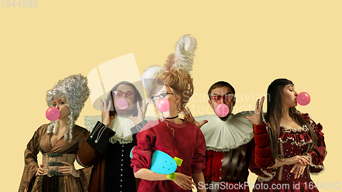 Image of Medieval people as a royalty persons in vintage clothing on yellow background. Concept of comparison of eras, modernity and renaissance. Creative collage.