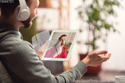 Image of Celebration and holidays during quarantine concept. Friends or family unpacking gifts while talking using video call